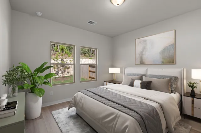 a bedroom with bed and a potted plant