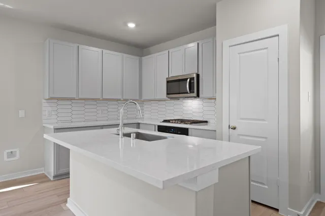 a kitchen with a sink a microwave a stove and refrigerator