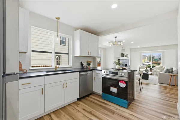 a kitchen with stainless steel appliances granite countertop a stove and white cabinets