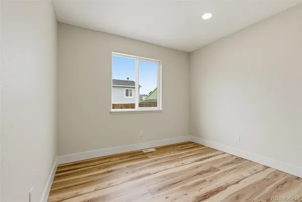 a view of empty room with wooden floor