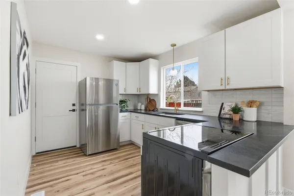a kitchen with a refrigerator a sink and cabinets