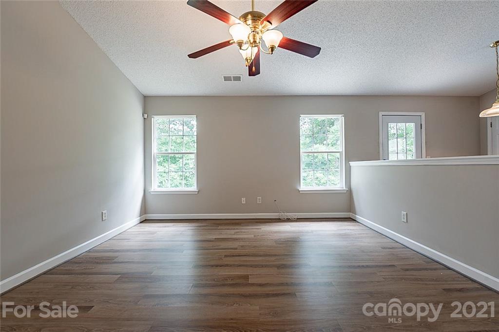 1665 Tate Road Rock Hill, SC 29732 - Photo 5 of 16 an empty room with wooden floor chandelier fan and windows