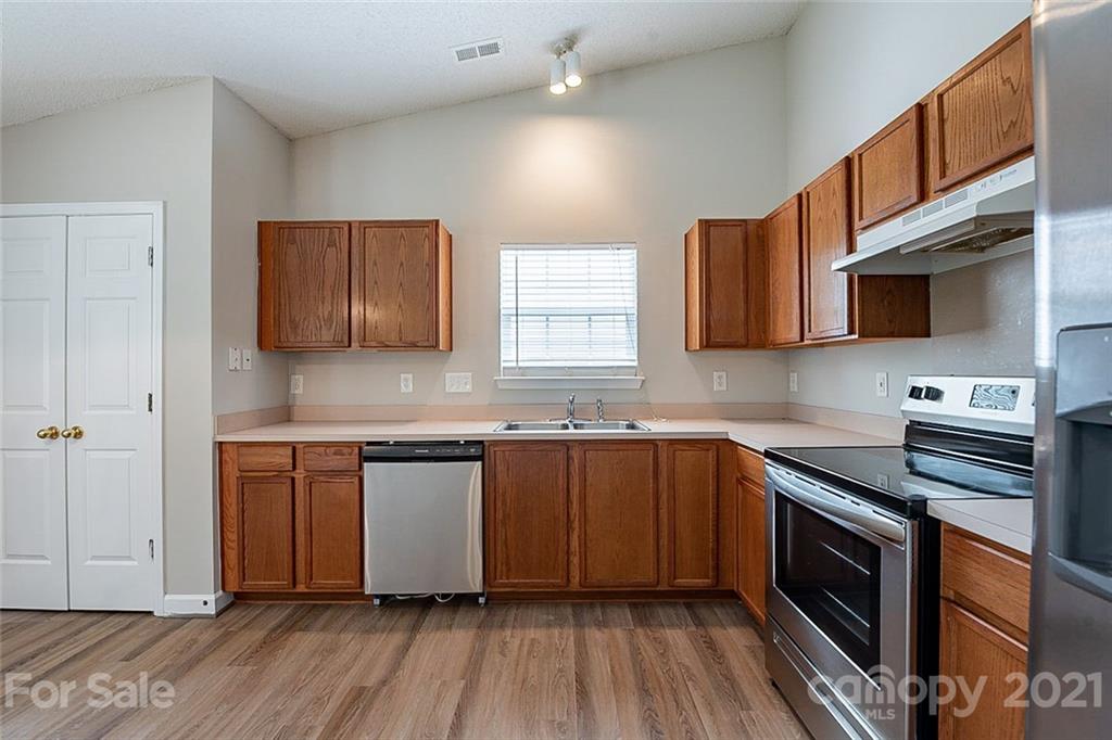 1665 Tate Road Rock Hill, SC 29732 - Photo 8 of 16 a kitchen with stainless steel appliances granite countertop wooden cabinets a stove top oven a sink and dishwasher