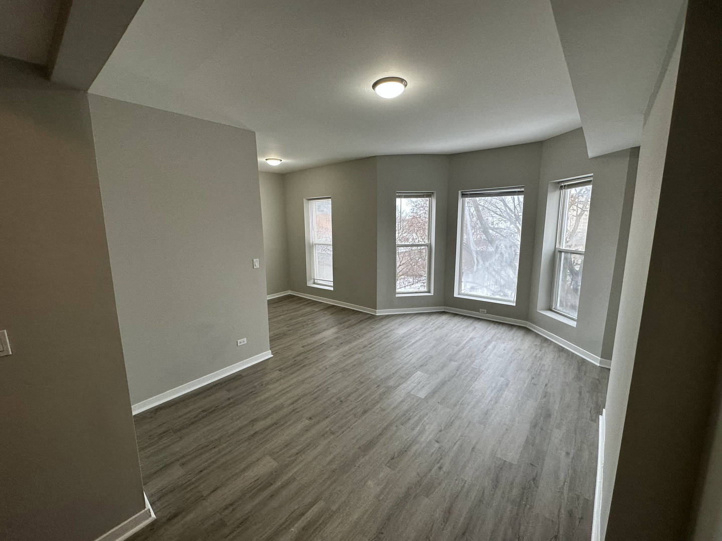 6320 South Drexel Avenue, Unit 3 Chicago, IL 60637 - Photo 3 of 13 an empty room with wooden floor and windows