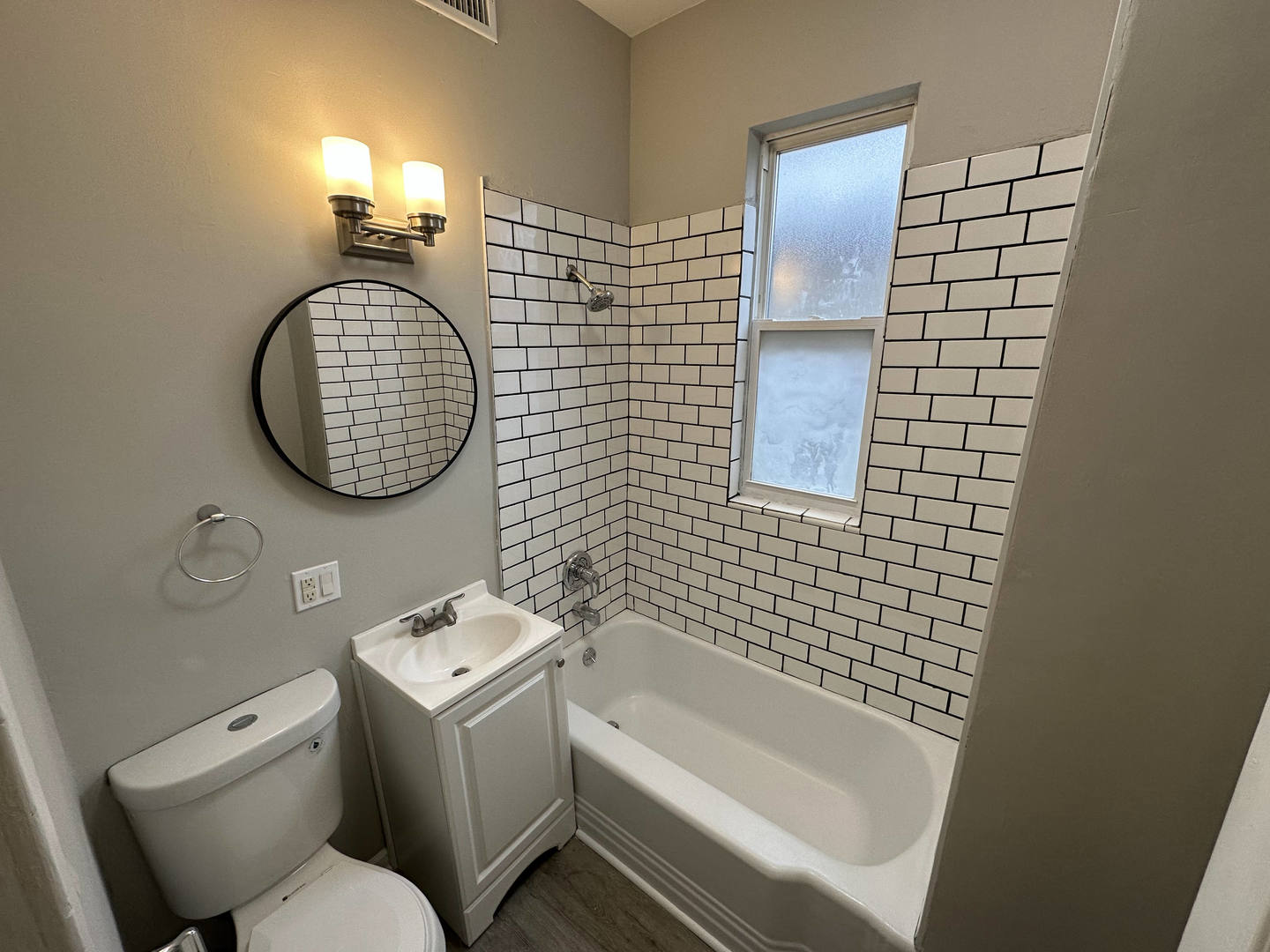 6320 South Drexel Avenue, Unit 3 Chicago, IL 60637 - Photo 8 of 13 a bathroom with a toilet sink vanity tub and mirror