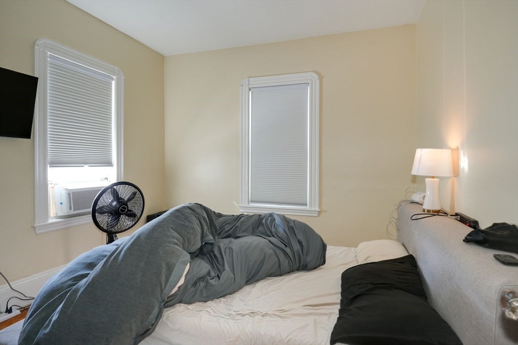 99 Beech Street Belmont, MA 02478 - Photo 30 of 37 a bedroom with a bed and a lamp