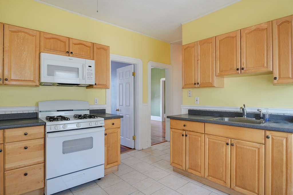 99 Beech Street Belmont, MA 02478 - Photo 5 of 37 a kitchen with granite countertop a sink stove and cabinets