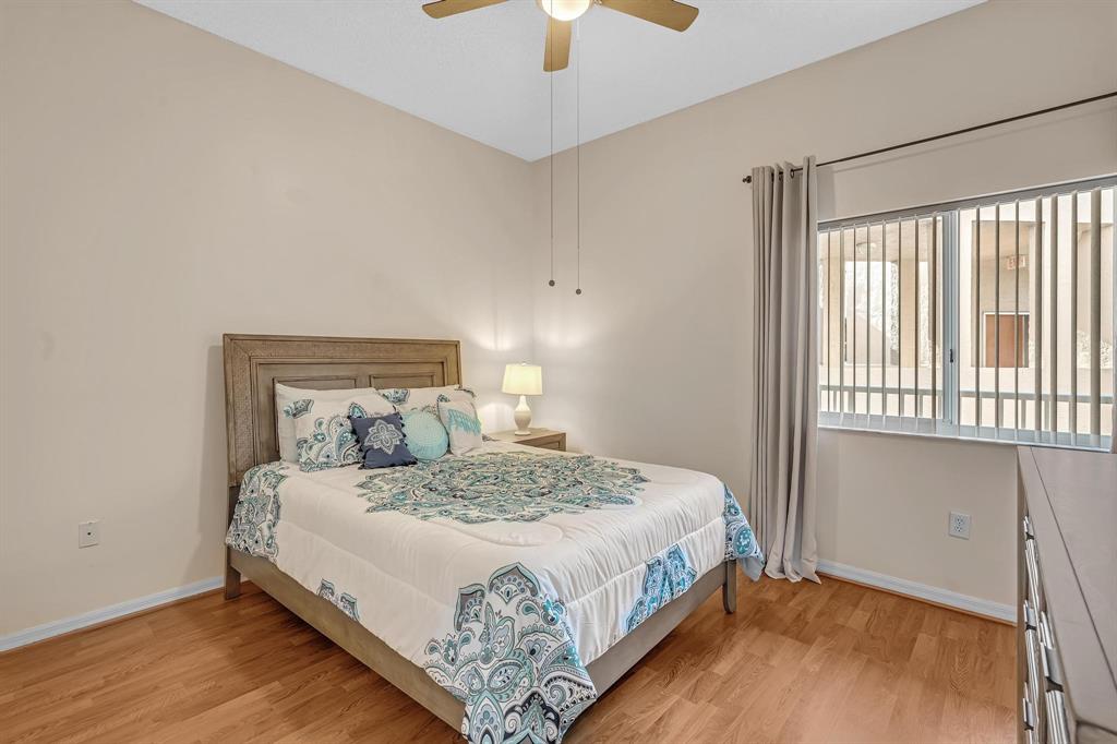 7802 Trent Drive, Unit 406 Fort Lauderdale, FL 33321 - Photo 25 of 70 a bedroom with a bed and a chandelier
