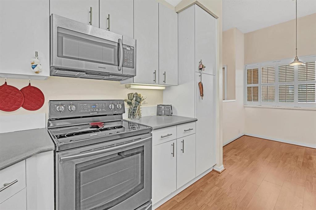 7802 Trent Drive, Unit 406 Fort Lauderdale, FL 33321 - Photo 4 of 70 a kitchen with cabinets appliances and a wooden floor