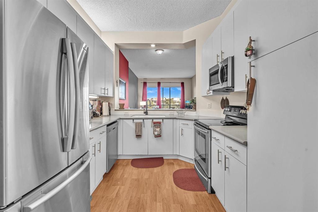 7802 Trent Drive, Unit 406 Fort Lauderdale, FL 33321 - Photo 5 of 70 a kitchen with stainless steel appliances granite countertop a refrigerator sink and white cabinets