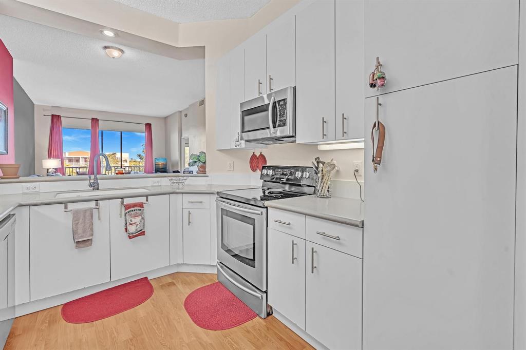 7802 Trent Drive, Unit 406 Fort Lauderdale, FL 33321 - Photo 6 of 70 a kitchen with stainless steel appliances a sink and cabinets