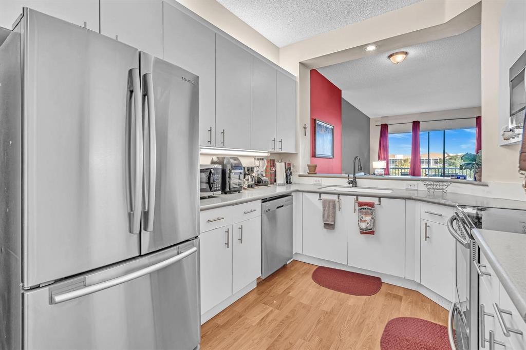 7802 Trent Drive, Unit 406 Fort Lauderdale, FL 33321 - Photo 7 of 70 a kitchen with stainless steel appliances a refrigerator sink and cabinets