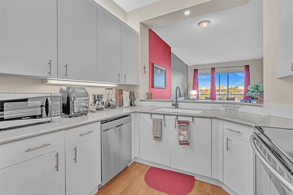 7802 Trent Drive, Unit 406 Fort Lauderdale, FL 33321 - Photo 8 of 70 a kitchen with white cabinets and sink
