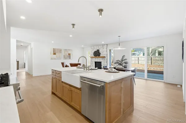 a large kitchen with kitchen island a sink a stove a refrigerator and white cabinets next to a window