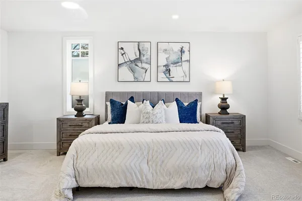 a bedroom with a bed and a painting on the wall