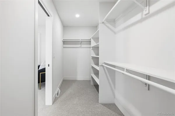 a view of walk in closet with empty racks