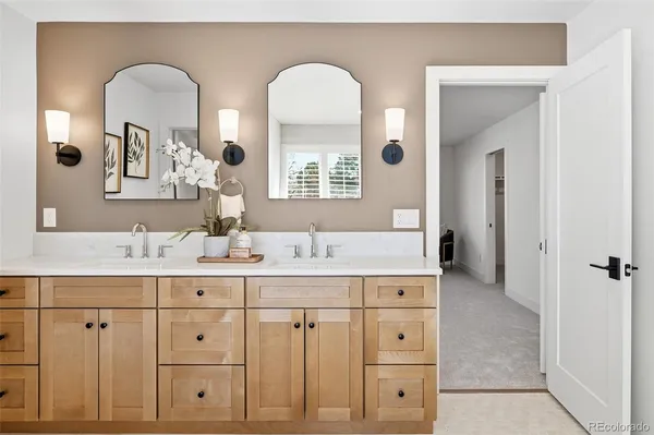 a bathroom with double vanity sinks and a mirror