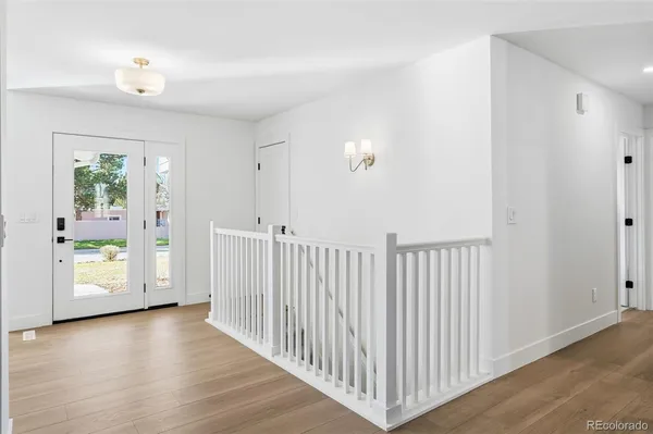 a view of a hallway with wooden floor and windows