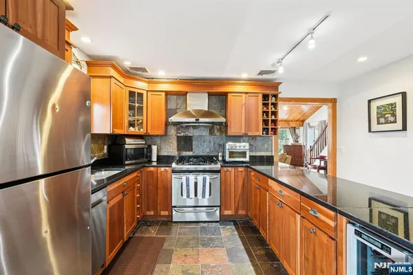 a kitchen with stainless steel appliances granite countertop a stove a sink and a refrigerator
