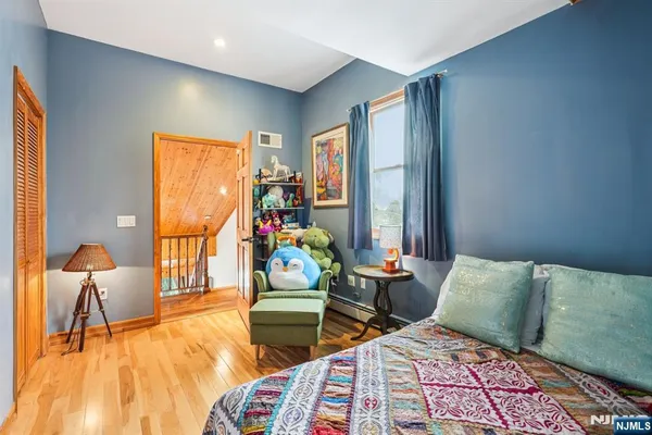 a bedroom with two beds and a dresser next to a window