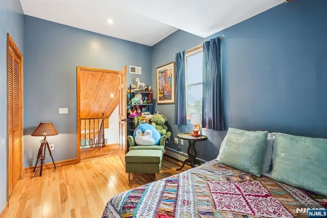 a bedroom with two beds and a dresser next to a window