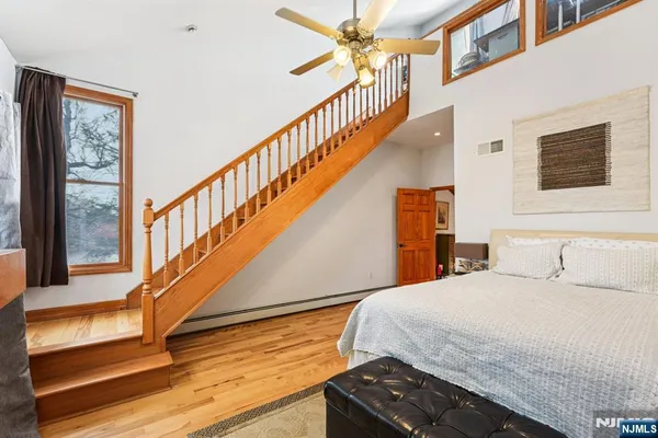 a bedroom with a bed and a wooden floor