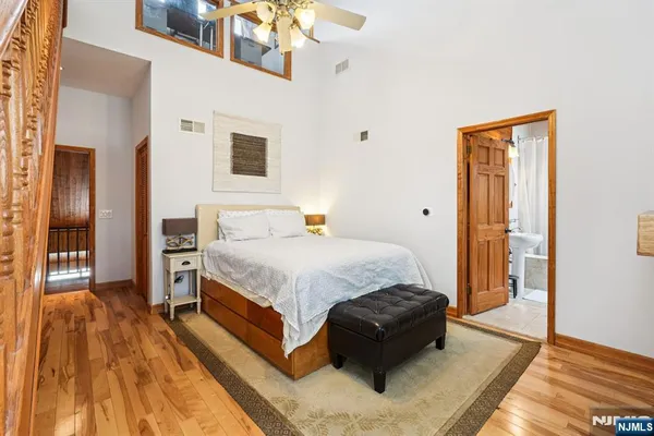 a spacious bedroom with a bed and wooden floor