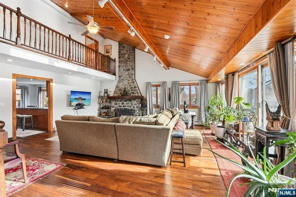 a living room with furniture a flat screen tv and a floor to ceiling window