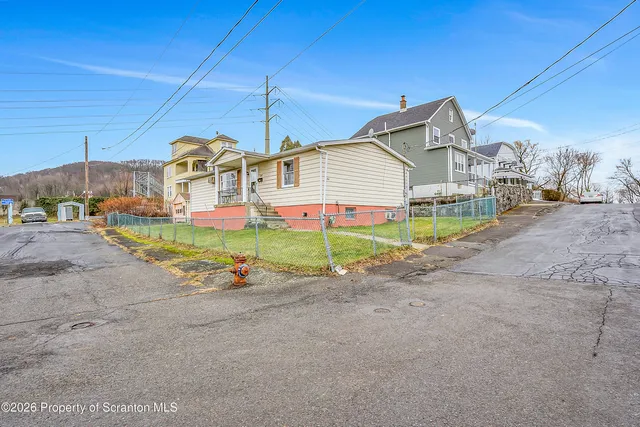 a view of a house with a yard and sitting area