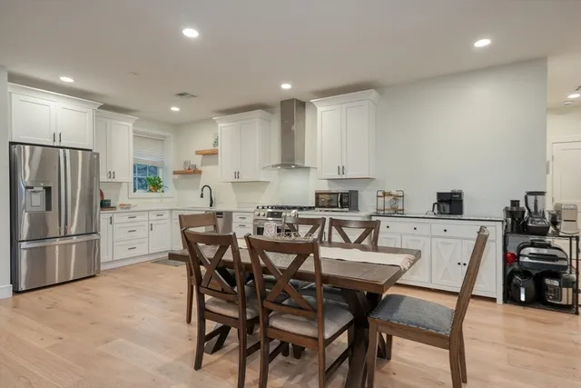 a kitchen with kitchen island a table and chairs in it