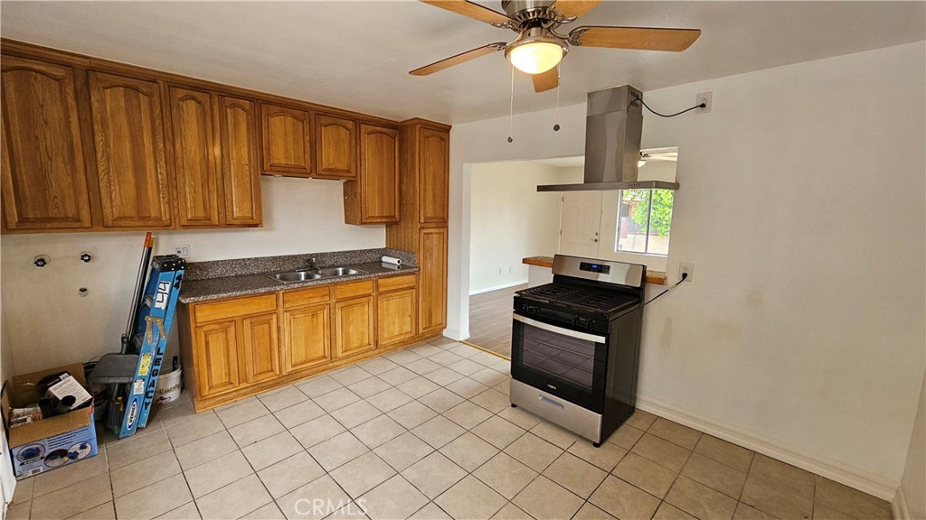 537 Ferris Street Los Angeles, CA 90022 - Photo 15 of 16 a kitchen with granite countertop a stove a sink and a microwave