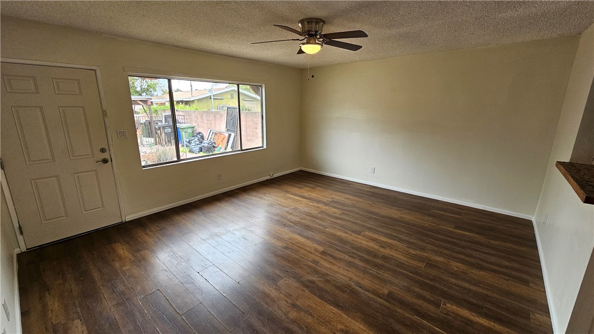 537 Ferris Street Los Angeles, CA 90022 - Photo 5 of 16 an empty room with wooden floor chandelier fan and windows