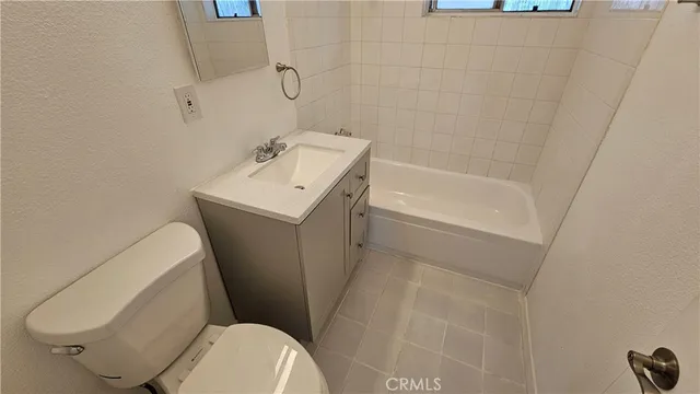 a white toilet sitting next to a bath tub