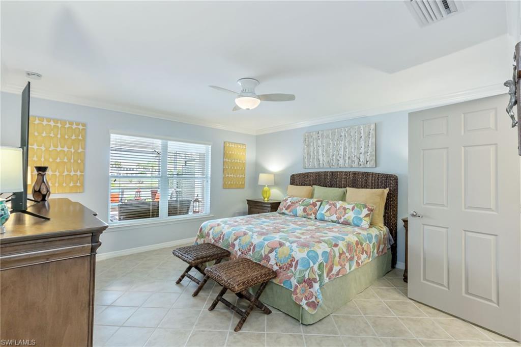 5801 Declaration Court Ave Maria, FL 34142 - Photo 14 of 38 a bedroom with a bed and a chandelier