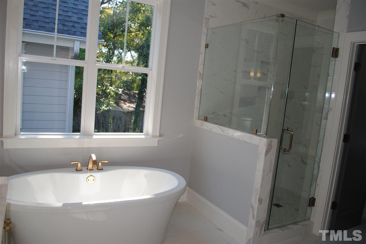 110 Revival Way Raleigh, NC 27608 - Photo 16 of 25 a white bath tub sitting in a bathroom next to a window