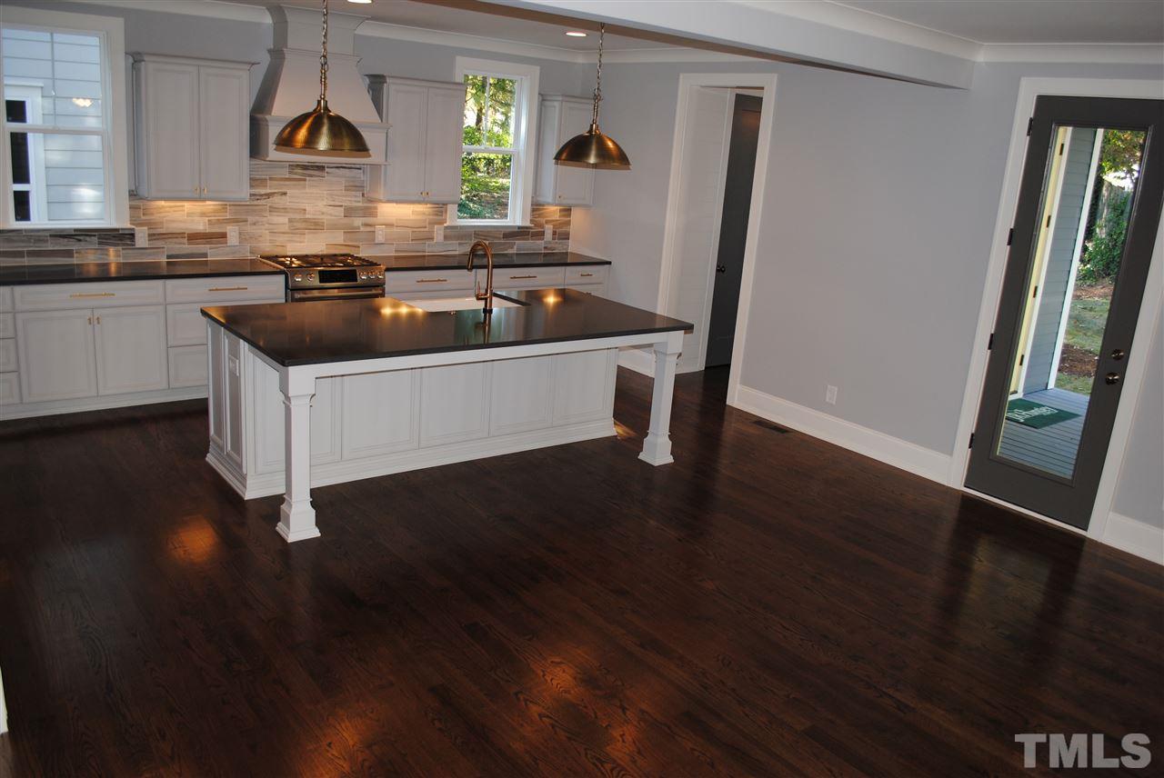 110 Revival Way Raleigh, NC 27608 - Photo 3 of 25 a kitchen with granite countertop a refrigerator a sink and wooden floor