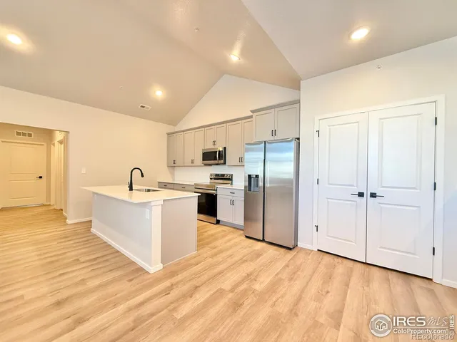 a large white kitchen with white cabinets and stainless steel appliances