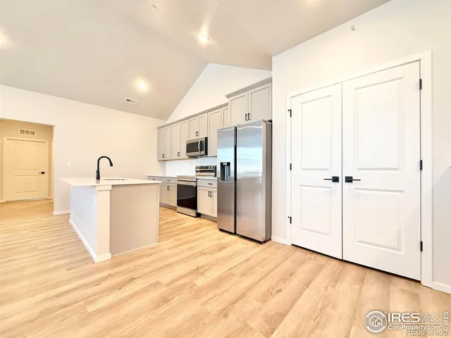 a view of kitchen with sink microwave refrigerator and cabinets