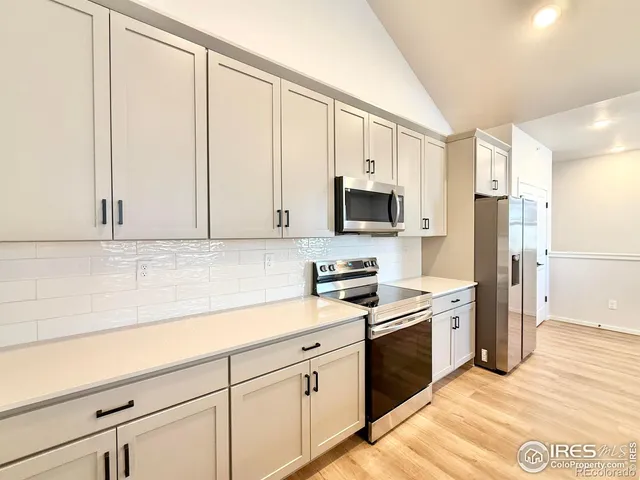 a kitchen with white cabinets and white appliances