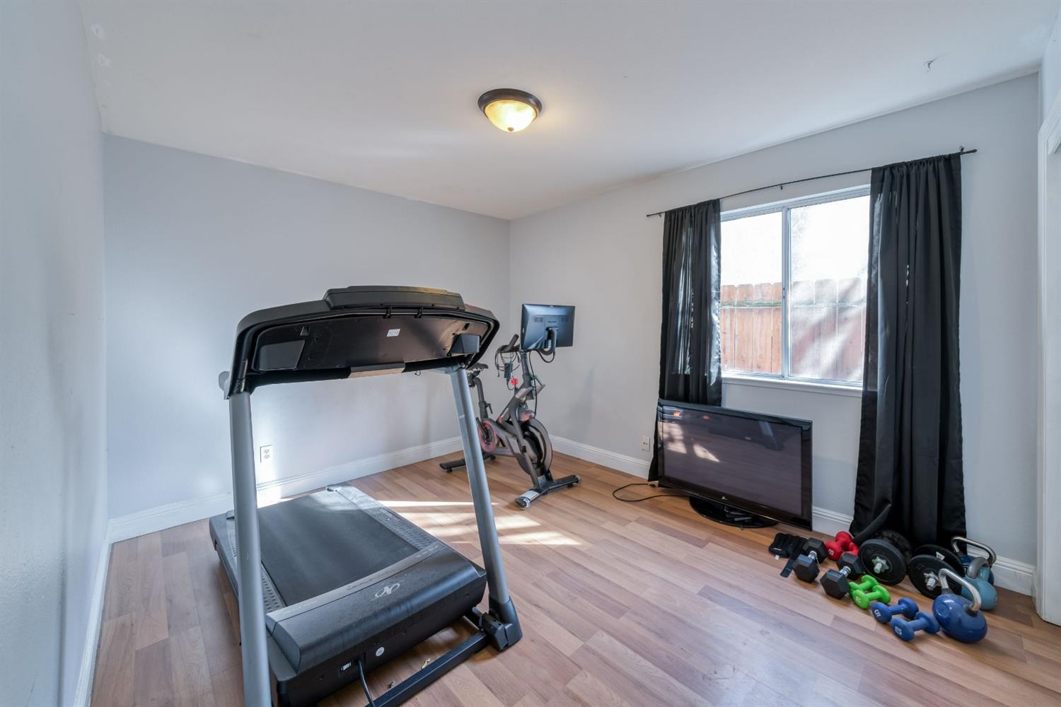 2505 Stuart Avenue Clovis, CA 93611 - Photo 11 of 23 a living room with furniture gym equipment and a window