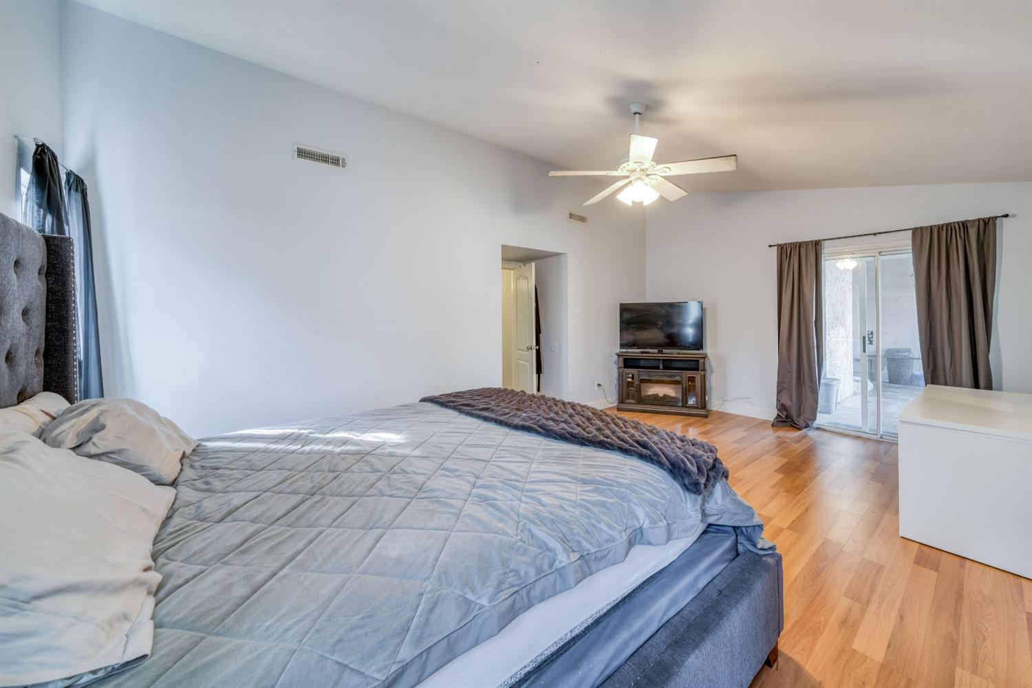 2505 Stuart Avenue Clovis, CA 93611 - Photo 13 of 23 a bedroom with a bed and a flat tv screen on a dresser