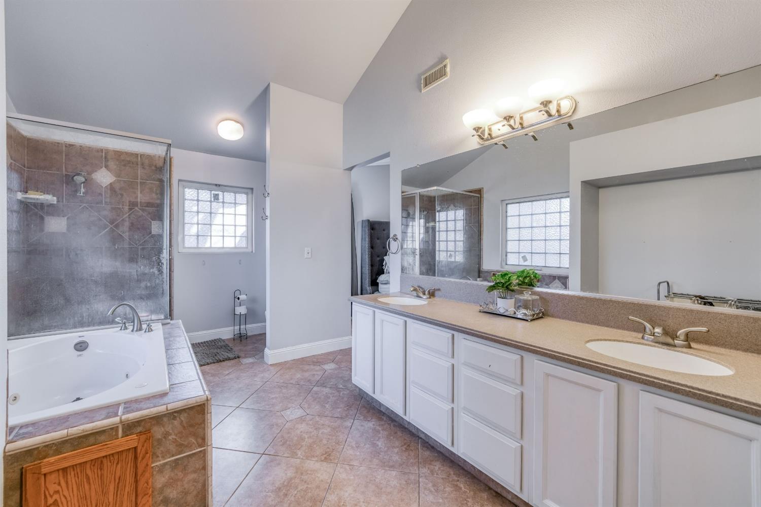 2505 Stuart Avenue Clovis, CA 93611 - Photo 14 of 23 a spacious bathroom with a granite countertop sink a toilet a bathtub a mirror and shower