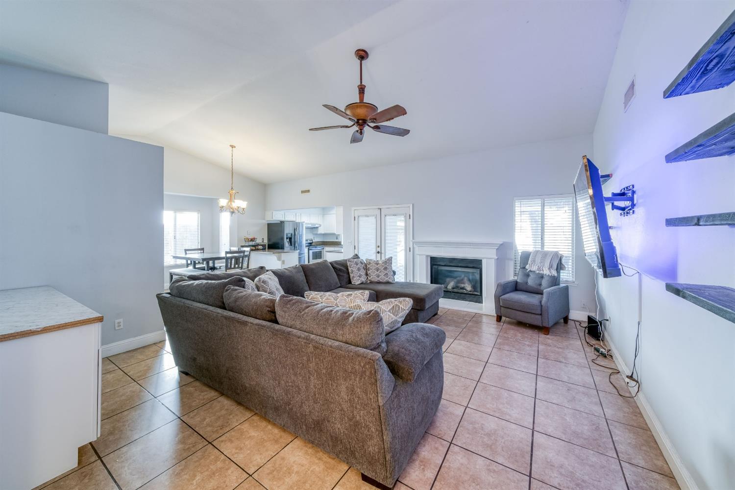 2505 Stuart Avenue Clovis, CA 93611 - Photo 2 of 23 a living room with furniture a fireplace and a chandelier