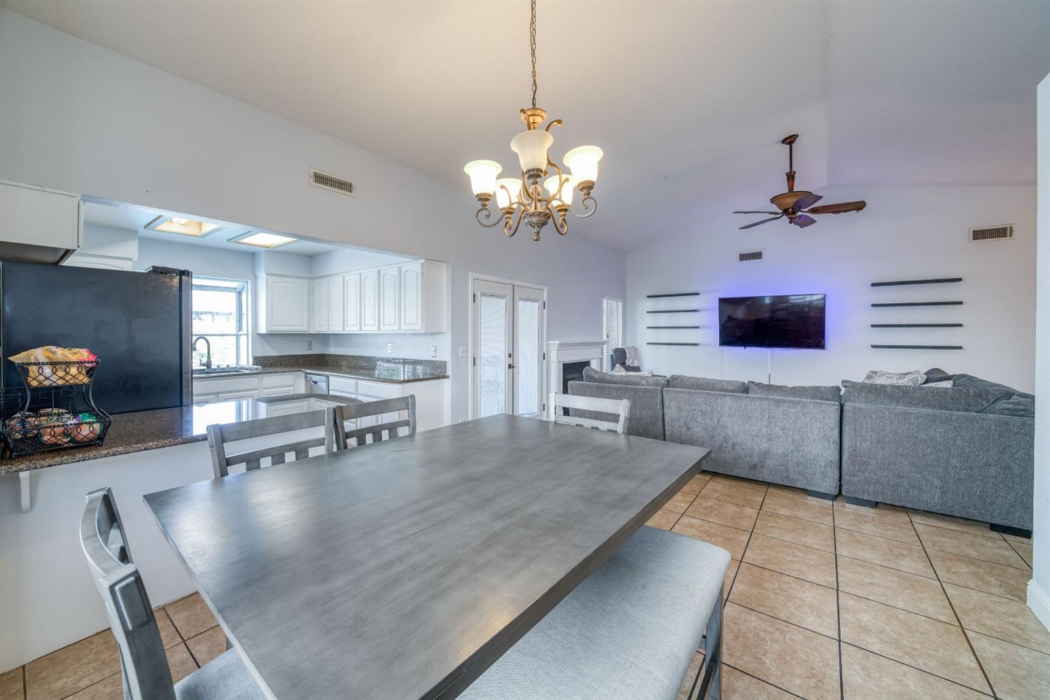 2505 Stuart Avenue Clovis, CA 93611 - Photo 6 of 23 a kitchen with stainless steel appliances granite countertop a refrigerator a sink dishwasher a dining table and chairs with wooden floor