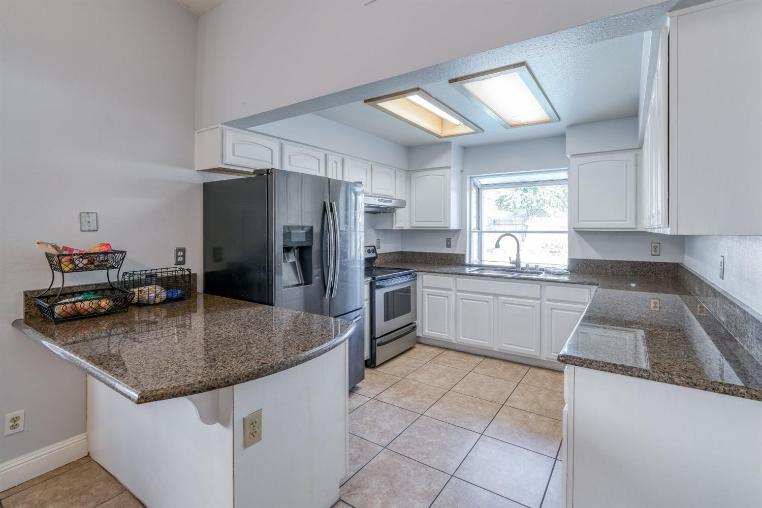 2505 Stuart Avenue Clovis, CA 93611 - Photo 7 of 23 a kitchen with granite countertop a sink a counter top space appliances and cabinets