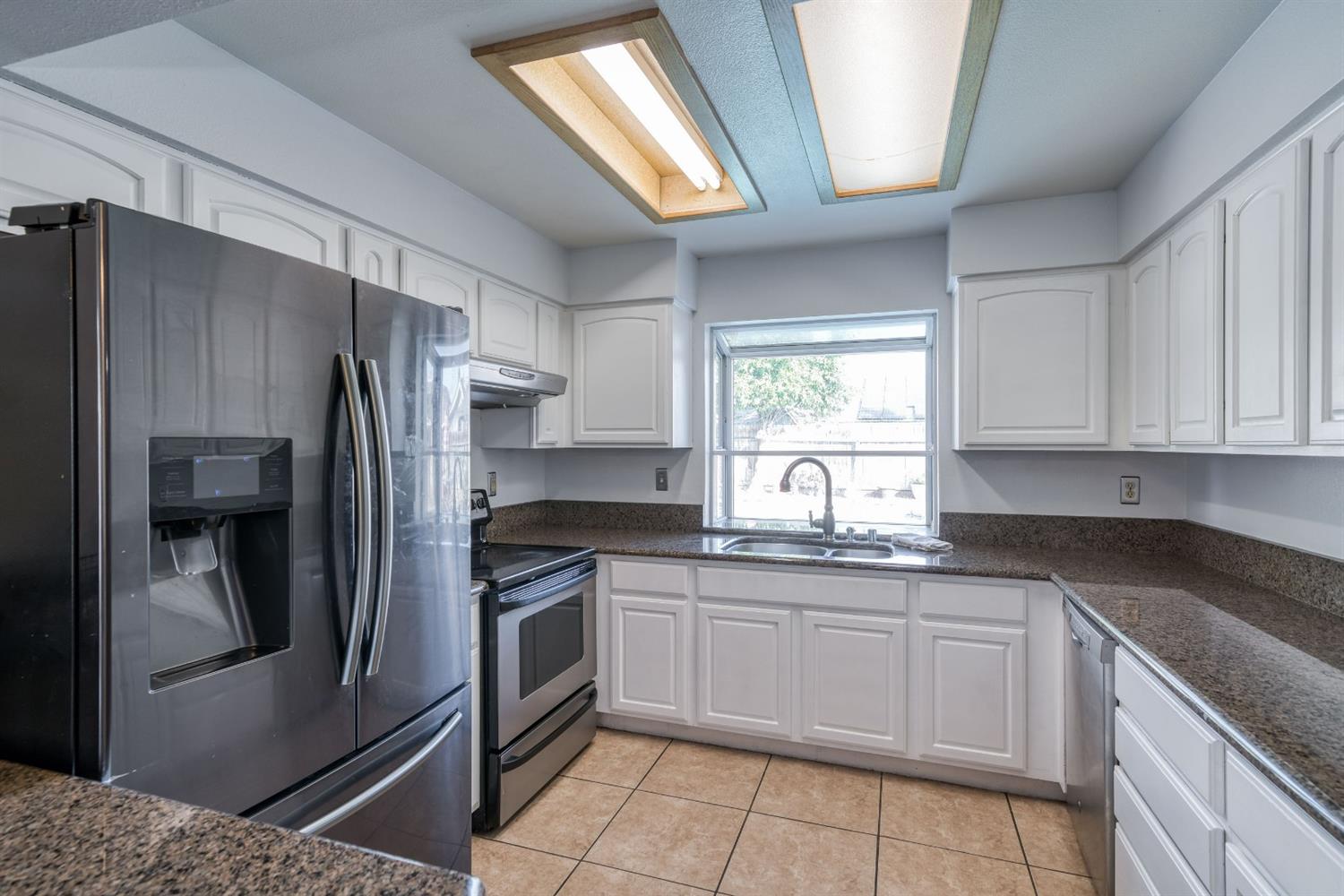 2505 Stuart Avenue Clovis, CA 93611 - Photo 8 of 23 a kitchen with stainless steel appliances granite countertop a refrigerator sink and cabinets