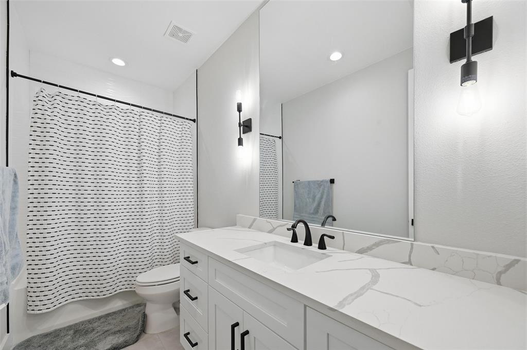 7733 Indian Ridge Trail Dallas, TX 75232 - Photo 12 of 30 a bathroom with a toilet a sink and mirror