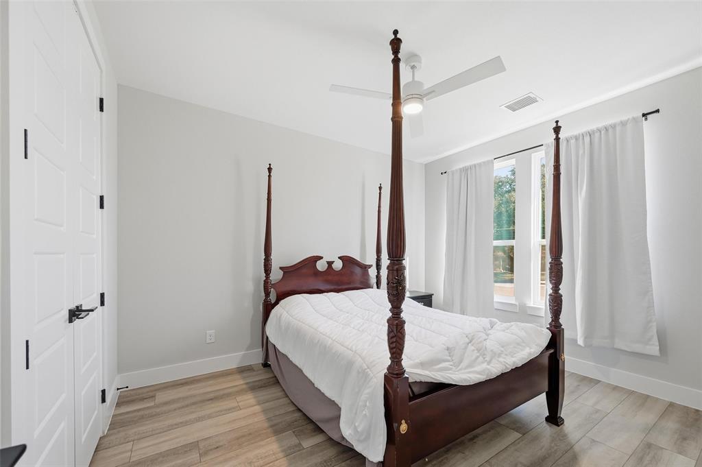 7733 Indian Ridge Trail Dallas, TX 75232 - Photo 13 of 30 a large bed sitting in a bedroom next to a window