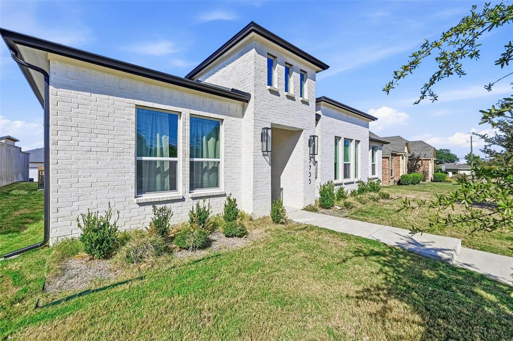 7733 Indian Ridge Trail Dallas, TX 75232 - Photo 27 of 30 a front view of a house with a yard and garage