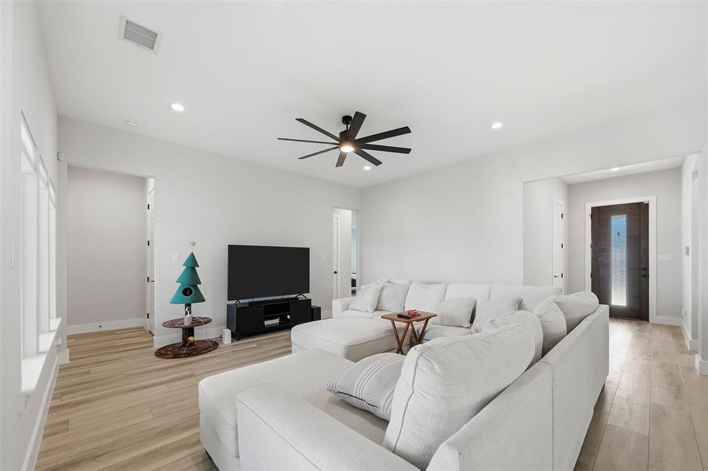 7733 Indian Ridge Trail Dallas, TX 75232 - Photo 3 of 30 a living room with furniture a flat screen tv and a ceiling fan